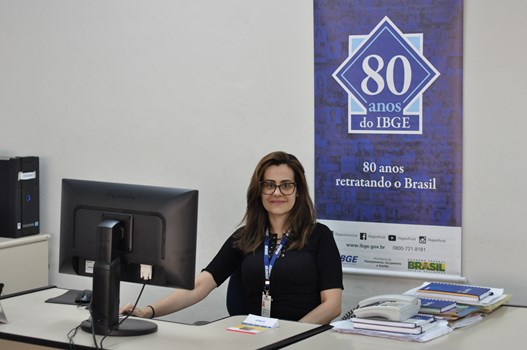 Ana Cândida Gontijo de Paiva, coordenadora do Censo em Juiz de Fora, sentada à mesa na agência do IBGE